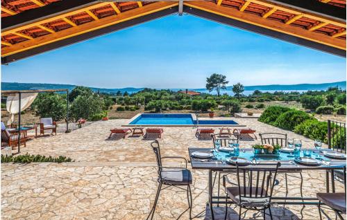 Un patio con mesa y sillas y una piscina. en Lovely Home In Sutivan, en Sutivan