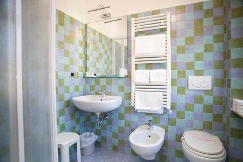 a bathroom with a sink and a toilet and a mirror at Hotel Garden in Levanto