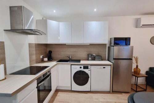 a kitchen with white cabinets and a refrigerator at Idéal 4 personnes 2 chambres et 2 salles de bain in Châteauroux