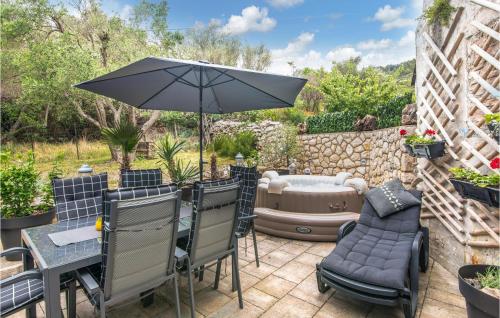 a patio with an umbrella and a hot tub at Cozy Home In Miholascica With Wifi in Miholašćica