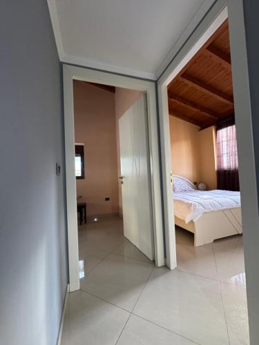 a bedroom with a bed and an open doorway at Kida's Guest House in Librazhd