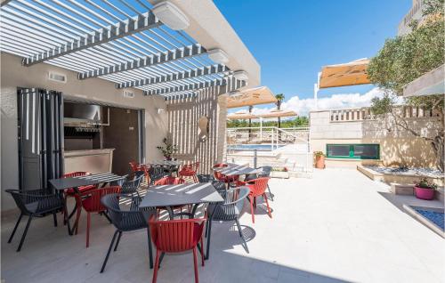 a patio with tables and chairs and a pool at Amazing Apartment In Novalja With Wifi in Novalja