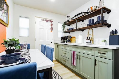 a kitchen with green cabinets and blue chairs at Star Motel Unit 2- Luxury Las Vegas Vacation Home Arts District Oasis in Las Vegas