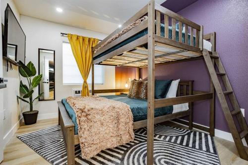 a bedroom with a bunk bed and purple walls at Star Motel Unit 2- Luxury Las Vegas Vacation Home Arts District Oasis in Las Vegas