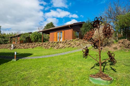 a metal plant in the grass in front of a house at Quinta dos Curubas in Vila Franca do Campo