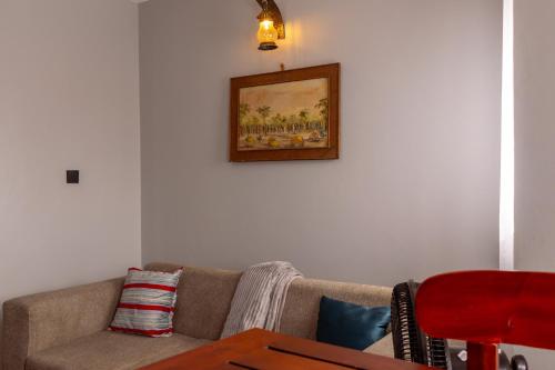 a living room with a couch and a picture on the wall at Matinza Homes, Makerere - 10min Drive to KLA City in Kampala