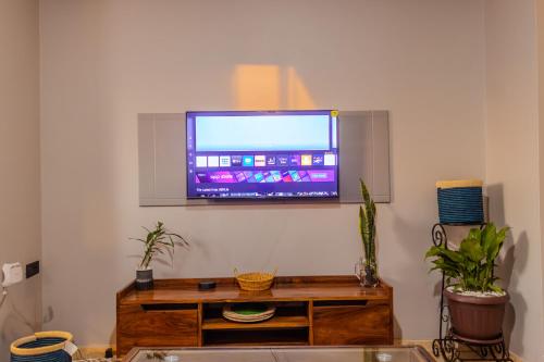 a living room with a television on a wall at Matinza Homes, Makerere - 10min Drive to KLA City in Kampala
