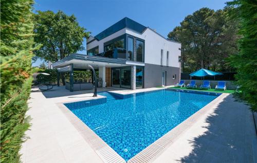 a house with a swimming pool in front of a house at Gorgeous Home In Fazana With Wifi in Fažana