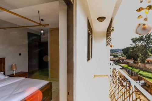a bedroom with a balcony with a bed and a view at Matinza Homes, Makerere - 10min Drive to KLA City in Kampala