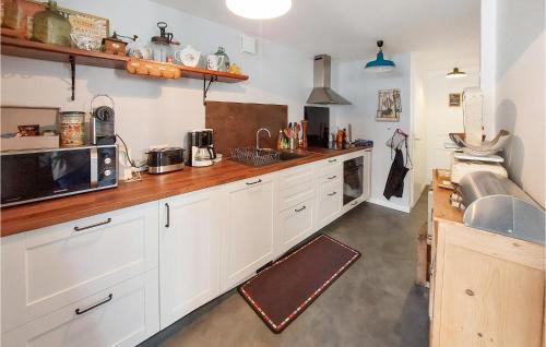 une cuisine avec des armoires blanches et un comptoir dans l'établissement Awesome Home In Margerie-Chantagret, à Soleymieux