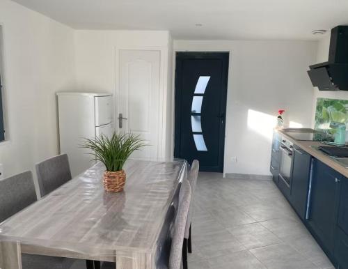 - une cuisine avec une table et une plante en pot dans l'établissement Maison du Champblanc 2 chambres, à Bourbon-Lancy