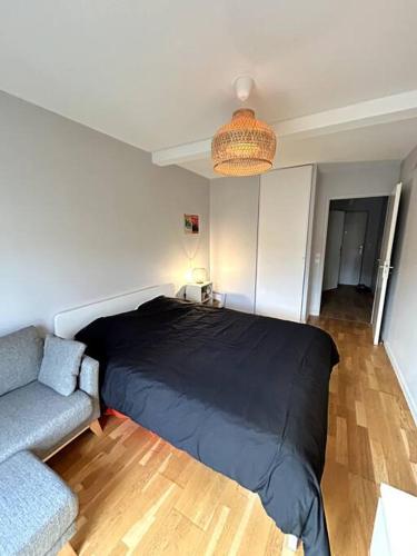 - une chambre avec un lit noir et un canapé dans l'établissement Le Copenhague - Parking privé, à Arras