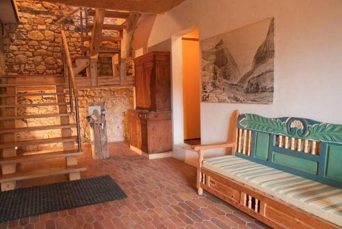 a living room with a couch and a stair case at Gîte Le Sappey en Chartreuse in Le Sappey-en-Chartreuse