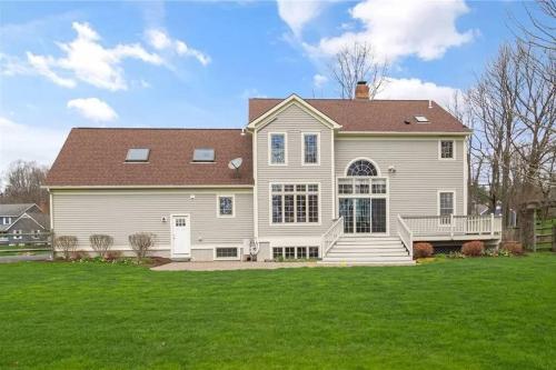 a large white house with a large yard at Cozy Ithaca Retreat - Fenced Yard - 7 min to Cornell in Ithaca