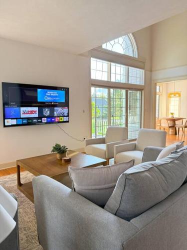 a living room with couches and a flat screen tv at Cozy Ithaca Retreat - Fenced Yard - 7 min to Cornell in Ithaca