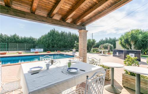 an outdoor patio with a table and a swimming pool at Lovely Home In Grammichele With Wifi in Grammichele