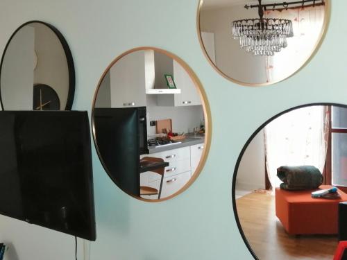 two round mirrors on a wall with a tv at Appartamento Angela in Cento