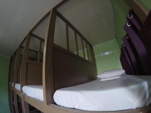 two bunk beds in a green room with white sheets at Malapascua Budget Inn MBI DIVE CENTER in Malapascua Island