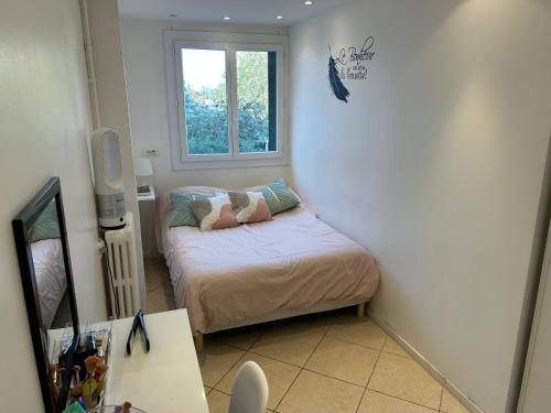 une petite chambre avec un lit et une fenêtre dans l'établissement Appartement Standing, Parkings devant le Velodrome, à Marseille