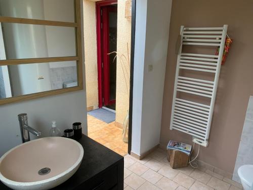 une salle de bain avec un lavabo blanc et un miroir dans l'établissement une chambre à la campagne, à Thouars