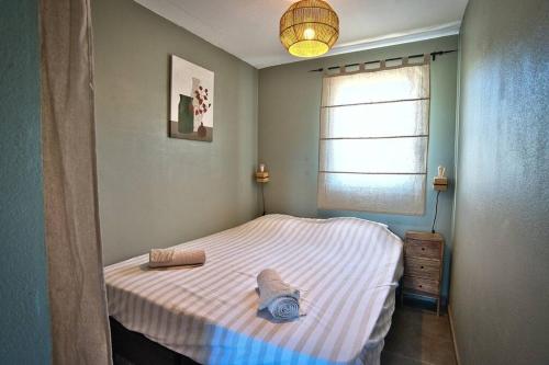 a small bed in a bedroom with a window at Appartement avec piscine in Uzès