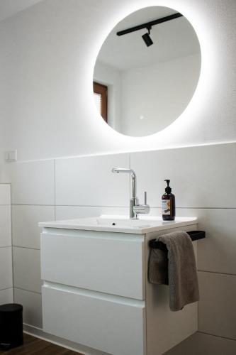 a white bathroom with a sink and a mirror at Ferienwohnung am Bollrich in Goslar
