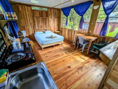 a kitchen with a bed and a sink in a room at Arboura Eco Cabins in Uvita