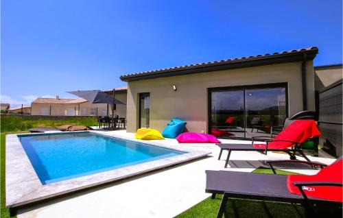 a backyard with a swimming pool and chairs and a house at Gorgeous Home In Cléon D'andran in Cléon-dʼAndran