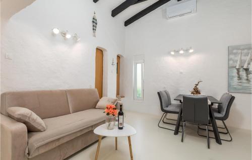 a living room with a couch and a table at Nice Home In Lopar With Jacuzzi in Lopar