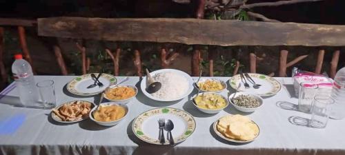 a table topped with plates and bowls of food at Relax Nature Villa in Sigiriya