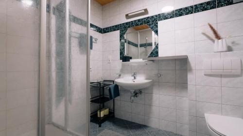 a white bathroom with a sink and a mirror at Apart Gipfelglück in Längenfeld