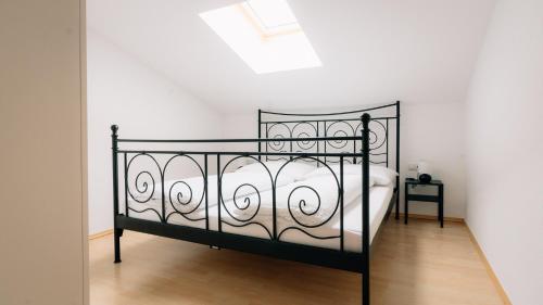 a bedroom with a black bed with white sheets at Apart Gipfelglück in Längenfeld