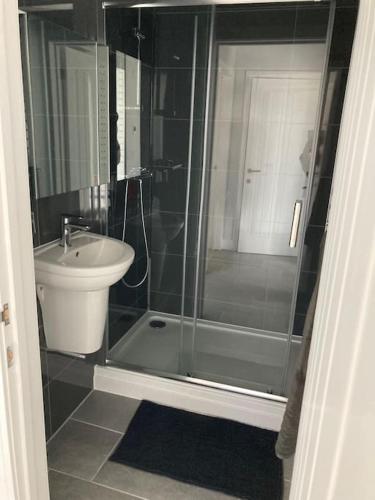 a bathroom with a glass shower and a sink at Purpose built 3 bedroom holiday barn in Bonvilston