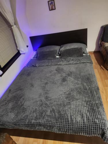 two beds in a room with a purple light at Quiet central studio in Pazardzhik