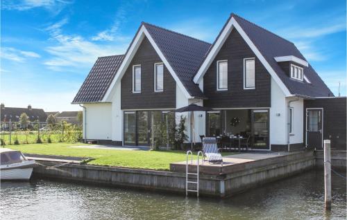 a house on a dock with a boat in the water at Cozy Home In Stavoren With Wifi in Stavoren