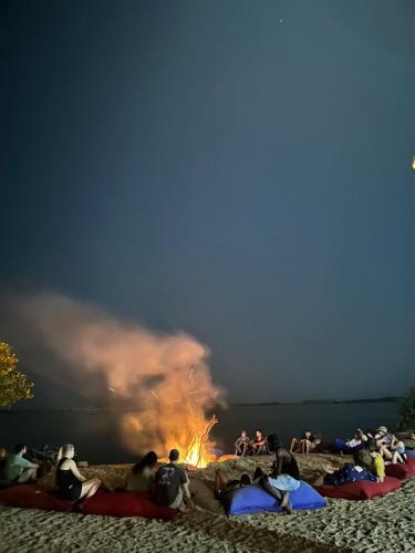 a group of people sitting around a fire on a beach at MKS - Kite & Wing Foil camp in Kalpitiya