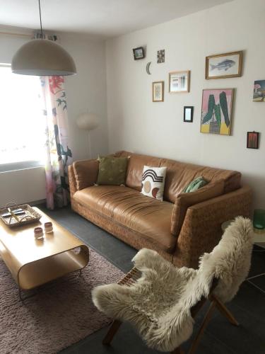 a living room with a brown couch and a table at Land Scape guesthouse in Eeklo