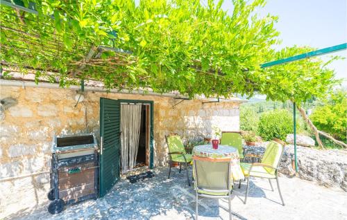 a patio with a table and chairs and a stove at Beautiful Home In Gruda With Wifi in Gruda