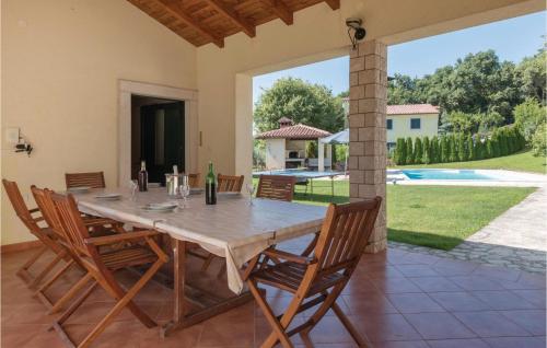 a dining room with a table and chairs and a pool at Beautiful Home In Liznjan With Sauna in Ližnjan