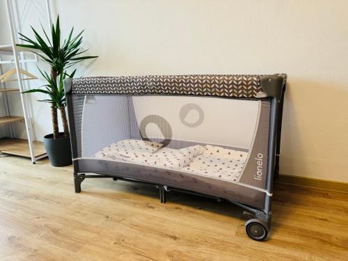 a small toy crib in a room with a plant at 3BR stay close to Munich City & Airport in Oberschleißheim