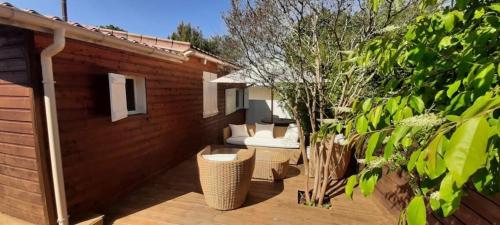 - un patio avec deux canapés sur une terrasse en bois dans l'établissement Hourtin Charmant Chalet avec Salon de Jardin, à Hourtin