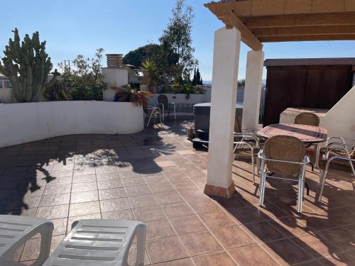 a patio with chairs and a table and a table and chairs at Penthouse with Private Roof terrace and jacuzzi in Fuengirola