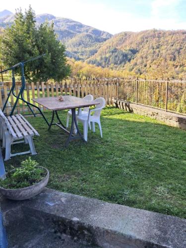 a picnic table and a bench in a yard at Casa Vacanza Margherita in Minucciano