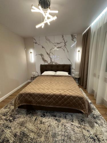 a bedroom with a bed with a tree mural on the wall at Apartments in center of Chisinau Anestiade in Chişinău