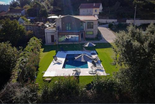 an aerial view of a house with a pool and umbrellas at Casa Fonte do Castelo - Casa de Campo in Monção