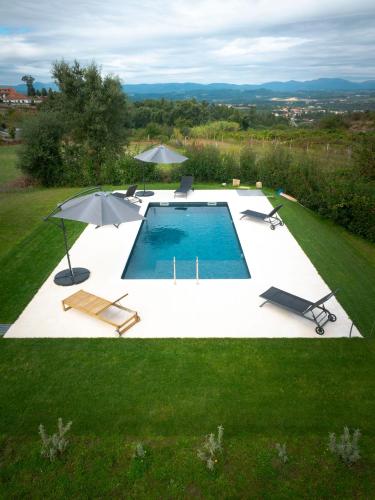 an overhead view of a pool with chairs and umbrellas at Casa Fonte do Castelo - Casa de Campo in Monção