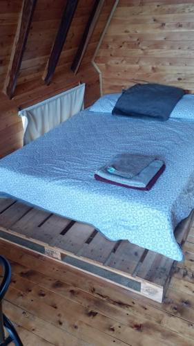 a bed in a room with a blue comforter on it at Lago Cristal Chalets in Bucaramanga