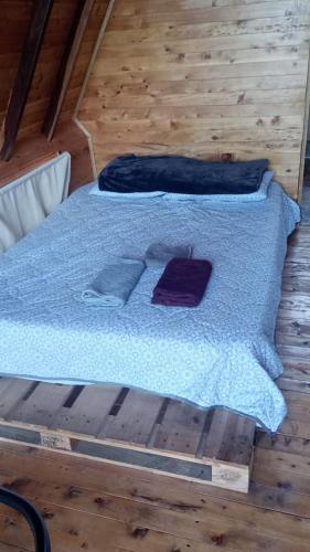 a bed with blue sheets and pillows on a wooden floor at Lago Cristal Chalets in Bucaramanga