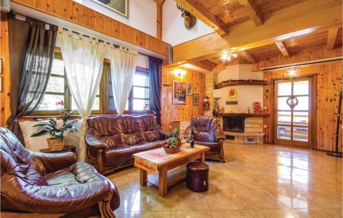 a living room with leather couches and a table at Cozy Home In Cujica Krcevina in Čujića Krčevina
