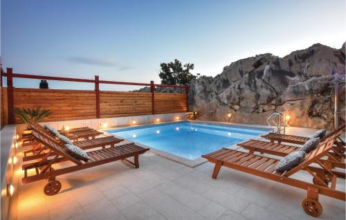 un patio avec une piscine et deux bancs et une piscine dans l'établissement Cozy Home In Podstrana With Sauna, à Podstrana